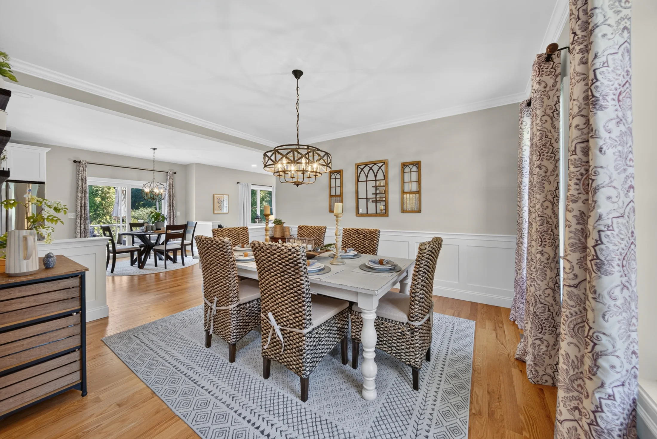 Dining room with woven chairs and a statement chandelier
