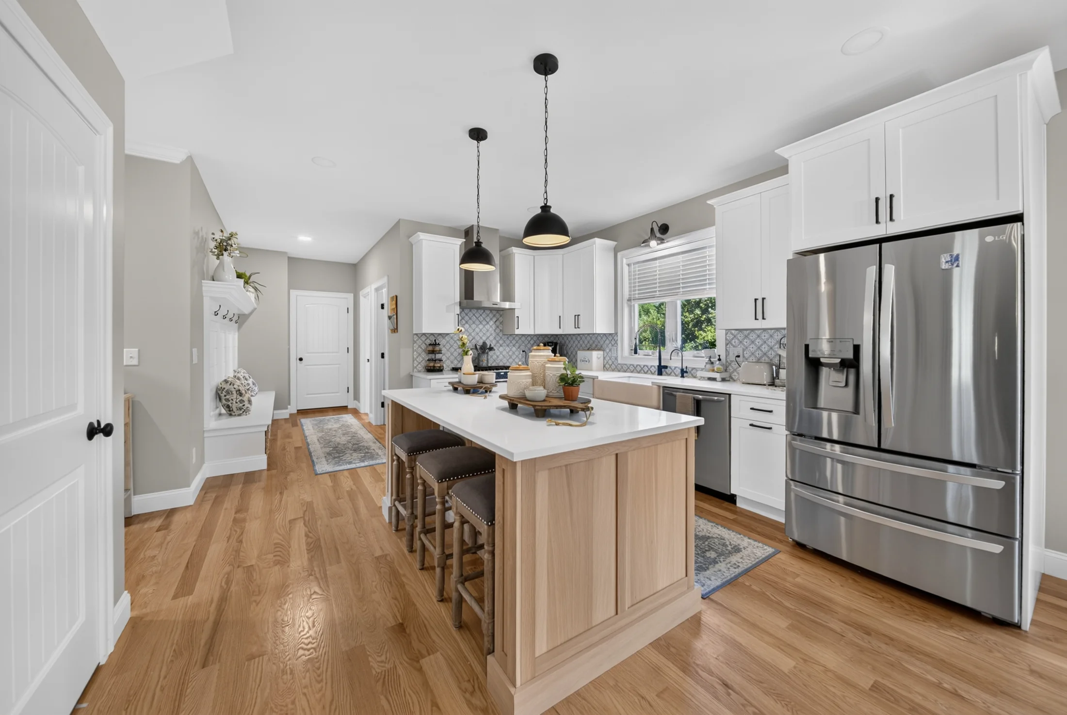 Sunlit white kitchen with a natural wood island, photographed by DH Media Solutions