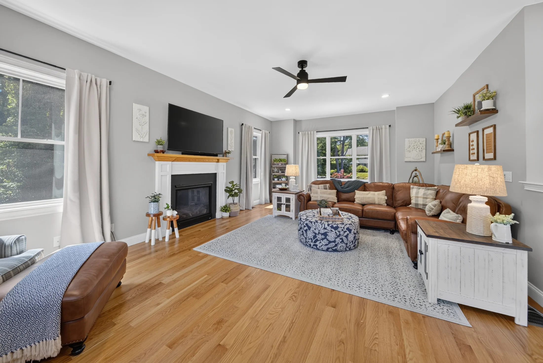 Inviting living room with a fireplace, large windows and leather seating